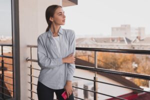 Kobieta na balkonie opiera się o balustradę
