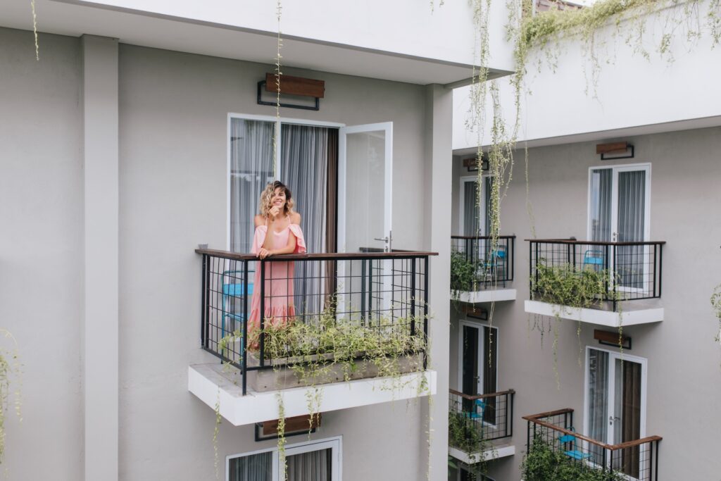 Kobieta na balkonie z balustradą w bloku
