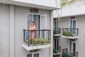 Kobieta na balkonie z balustradą w bloku
