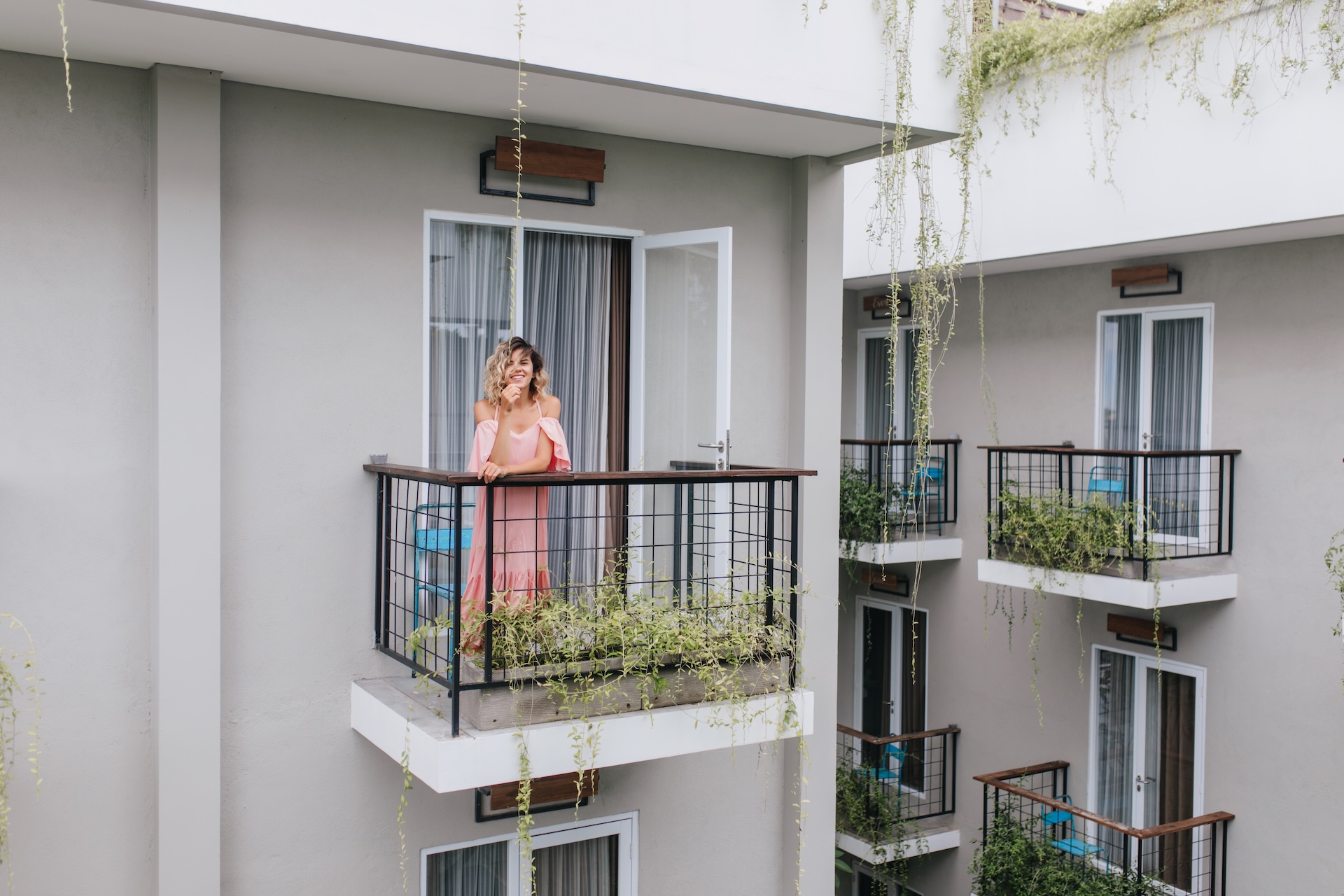 Kobieta na balkonie z balustradą w bloku